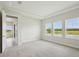 Bright main bedroom with tray ceiling and large windows overlooking the water at 35571 Stableton Ln, Zephyrhills, FL 33541
