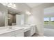 Bright bathroom featuring double sink vanity with white cabinets and a large mirror at 35579 Stableton Ln, Zephyrhills, FL 33541