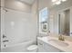 Bright bathroom features a combination tub and shower, white tile, and vanity at 35579 Stableton Ln, Zephyrhills, FL 33541