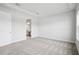 Carpeted bedroom featuring a tray ceiling and nearby bathroom with bright natural lighting at 35579 Stableton Ln, Zephyrhills, FL 33541