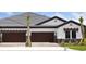 Beautiful home featuring a three-car garage, a well-manicured lawn, and decorative stone accents at 35579 Stableton Ln, Zephyrhills, FL 33541
