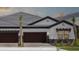 Beautiful home featuring a three-car garage, a well-manicured lawn, and decorative stone accents at 35579 Stableton Ln, Zephyrhills, FL 33541
