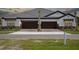 Beautiful home exterior featuring two garages, stone accents, and a well-kept lawn at 35579 Stableton Ln, Zephyrhills, FL 33541