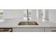 Close up of a kitchen island featuring stainless steel sink, white countertops and cabinets at 35579 Stableton Ln, Zephyrhills, FL 33541