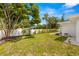 Spacious backyard with white privacy fence, mature trees, and lush green grass at 3801 Dr Martin Luther King Jr N St, St Petersburg, FL 33703