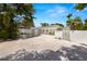 Charming single-story home featuring stylish gates, lush trees and white exterior at 3801 Dr Martin Luther King Jr N St, St Petersburg, FL 33703