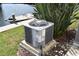 Exterior view of the home's air conditioner unit and a glimpse of the waterfront at 420 Moorings Cove Dr # 420, Tarpon Springs, FL 34689