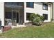 The backyard features a lawn with vegetation and sliding glass door access to the screened patio at 420 Moorings Cove Dr # 420, Tarpon Springs, FL 34689