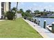 Waterfront view with a dock, boat, lush lawn, and landscaping at 420 Moorings Cove Dr # 420, Tarpon Springs, FL 34689