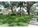View of the meticulously landscaped community lawn, featuring kayak storage and a bench at 420 Moorings Cove Dr # 420, Tarpon Springs, FL 34689