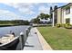 Waterfront view with a dock, boat, and manicured lawn at 420 Moorings Cove Dr # 420, Tarpon Springs, FL 34689