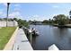 Waterfront view with a dock, boat, and mature landscaping at 420 Moorings Cove Dr # 420, Tarpon Springs, FL 34689