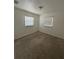Bright bedroom with neutral walls, two windows, and carpet flooring at 4506 Eden Rock Rd, Tampa, FL 33634