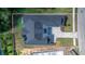 Aerial view of a modern home showcasing its unique roofline, manicured lawn, and elegant driveway at 4522 Majestic Hills Loop, Brooksville, FL 34601