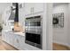 This stylish kitchen features stainless steel appliances, white cabinets, and a decorative tile backsplash at 4522 Majestic Hills Loop, Brooksville, FL 34601