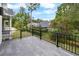 A spacious balcony with black railing overlooking a lush backyard and neighboring houses at 4522 Majestic Hills Loop, Brooksville, FL 34601