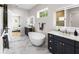 A contemporary bathroom featuring dual vanities, a freestanding tub, marble floors, and modern lighting at 4522 Majestic Hills Loop, Brooksville, FL 34601