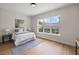 Bright bedroom boasts large window, neutral walls, wood floors and contemporary decor at 4522 Majestic Hills Loop, Brooksville, FL 34601