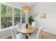 A breakfast nook features large windows that bring in plenty of natural light, highlighting the wooden table and white chairs at 4522 Majestic Hills Loop, Brooksville, FL 34601