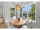 Sun-filled breakfast nook features a round table, white chairs, and large windows overlooking the backyard at 4522 Majestic Hills Loop, Brooksville, FL 34601