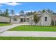 Well-manicured lawn and landscaping accentuate this modern gray home with a welcoming front porch at 4522 Majestic Hills Loop, Brooksville, FL 34601