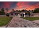 Stunning one-story home with a patterned paver driveway and a two-car garage set against a colorful sunset at 4522 Majestic Hills Loop, Brooksville, FL 34601