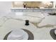 Close-up of kitchen island with quartz countertop, pop up outlet, and place settings at 4522 Majestic Hills Loop, Brooksville, FL 34601