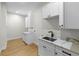 Well-lit laundry room with stainless steel sink, quartz countertops, and modern cabinets at 4522 Majestic Hills Loop, Brooksville, FL 34601