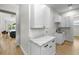 White cabinets and countertops in a laundry room, leading into an open kitchen with modern appliances at 4522 Majestic Hills Loop, Brooksville, FL 34601