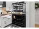 Stainless steel appliances and ovens in a modern kitchen with custom white cabinetry at 4522 Majestic Hills Loop, Brooksville, FL 34601