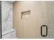 Walk-in shower featuring a built-in niche and marble and wood-look tiling at 4522 Majestic Hills Loop, Brooksville, FL 34601