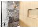 Walk-in shower featuring marble tiling and wood paneling with shower niche for optimal storage at 4522 Majestic Hills Loop, Brooksville, FL 34601