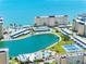 Aerial view of the lake, surrounding buildings, tennis courts and ocean at 4700 Cove Cir # 301, St Petersburg, FL 33708