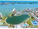 An aerial view showing a lake surrounded by buildings, tennis court and ocean at 4700 Cove Cir # 301, St Petersburg, FL 33708