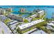An aerial view showcases the condo community with its pool, tennis courts, pond and various buildings at 4700 Cove Cir # 301, St Petersburg, FL 33708