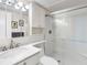 Bright bathroom featuring a walk-in shower with glass door, a vanity with sink, and updated fixtures at 4700 Cove Cir # 301, St Petersburg, FL 33708