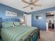 Blue bedroom with closet, ceiling fan, en suite bathroom, and a window with shutters at 4700 Cove Cir # 301, St Petersburg, FL 33708