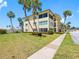 Beautiful multi-story condo building surrounded by lush landscaping and swaying palm trees on a sunny day at 4700 Cove Cir # 301, St Petersburg, FL 33708