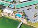 Aerial close up view of a swimming pool with lounge chairs and a pier leading to the water at 4700 Cove Cir # 301, St Petersburg, FL 33708