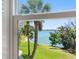 Picturesque water view through the window, highlighting the serene scenery and beautiful palm trees at 4700 Cove Cir # 301, St Petersburg, FL 33708