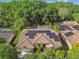 An aerial view of a home featuring solar panels on the roof and a beautiful wooded lot at 5027 Cross Pointe Dr, Oldsmar, FL 34677