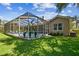 Spacious backyard with a screened-in pool, well-manicured lawn, and lush trees, perfect for outdoor entertaining at 5027 Cross Pointe Dr, Oldsmar, FL 34677