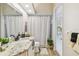 Bathroom featuring a granite countertop, framed mirror, tiled shower, and decorative accents at 5027 Cross Pointe Dr, Oldsmar, FL 34677