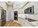 Kitchen featuring stainless appliances, granite countertops, subway tile backsplash, white cabinets, and wood flooring at 5027 Cross Pointe Dr, Oldsmar, FL 34677