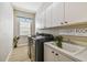 Functional laundry room featuring modern appliances, cabinets, and a sink with a decorative sign at 5027 Cross Pointe Dr, Oldsmar, FL 34677