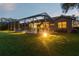 Backyard view of screened pool at dusk with lush landscaping surrounding the property at 5027 Cross Pointe Dr, Oldsmar, FL 34677