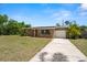 Charming stone house featuring mature landscaping, lush lawn, and driveway at 5302 44Th N Ave, St Petersburg, FL 33710