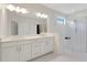 All-white bathroom with double sinks, a walk-in shower, and large vanity mirror at 5410 Morey Farms Loop, Palmetto, FL 34221