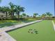 Bocce ball court surrounded by green landscaping and palm trees on a sunny day at 5410 Morey Farms Loop, Palmetto, FL 34221