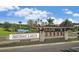 Artisan Lakes community entrance sign framed by lush landscaping, lake, and blue skies at 5410 Morey Farms Loop, Palmetto, FL 34221